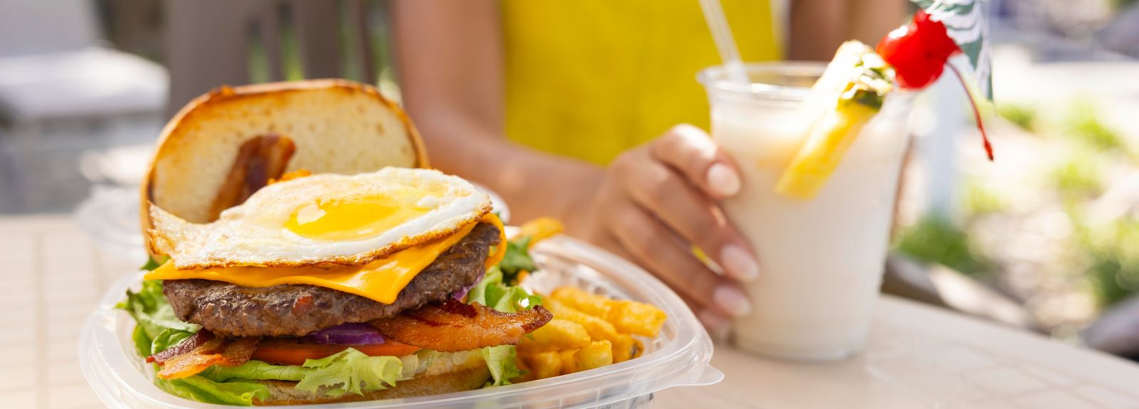 a burger and fries in a plastic container