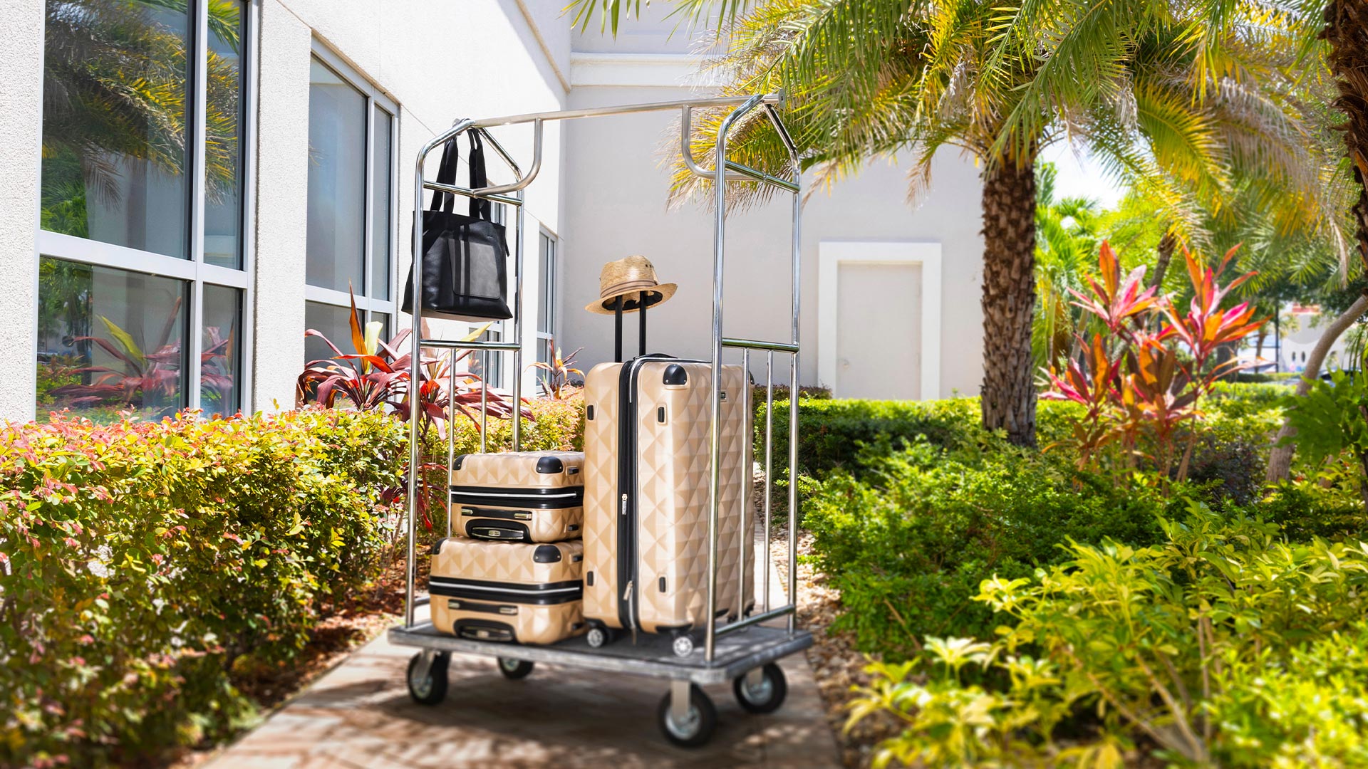 set of peach color luggage set up on a bellmans cart