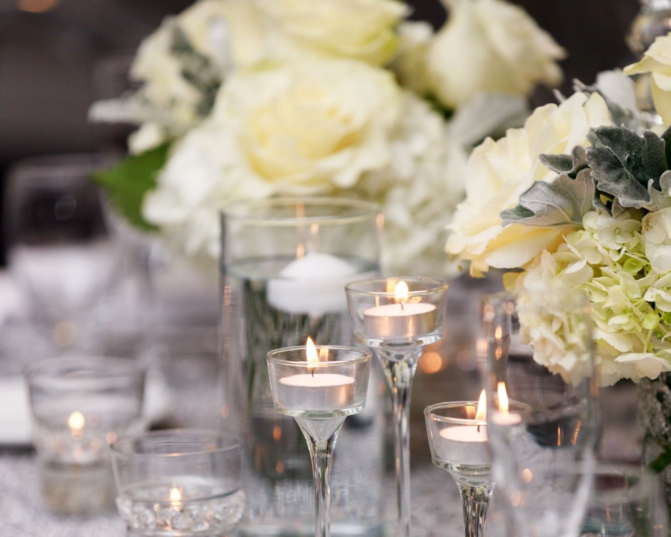 votive candles and white floral centerpieces at a wedding